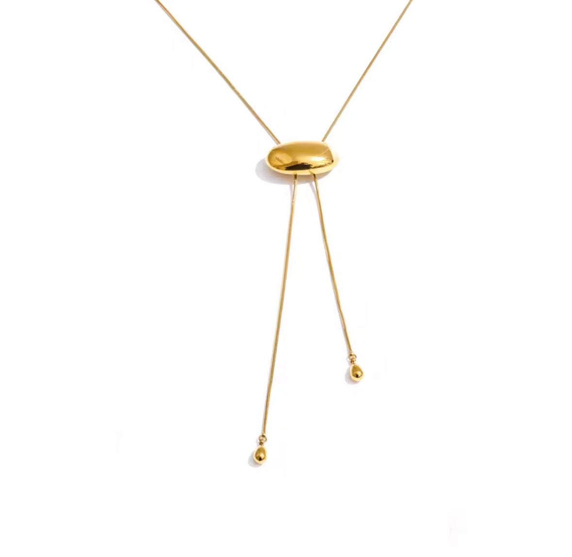 A gold Y-shaped dangle necklace with a polished oval centerpiece and two thin dangling chains ending in small bead drops, shown on a plain white background.