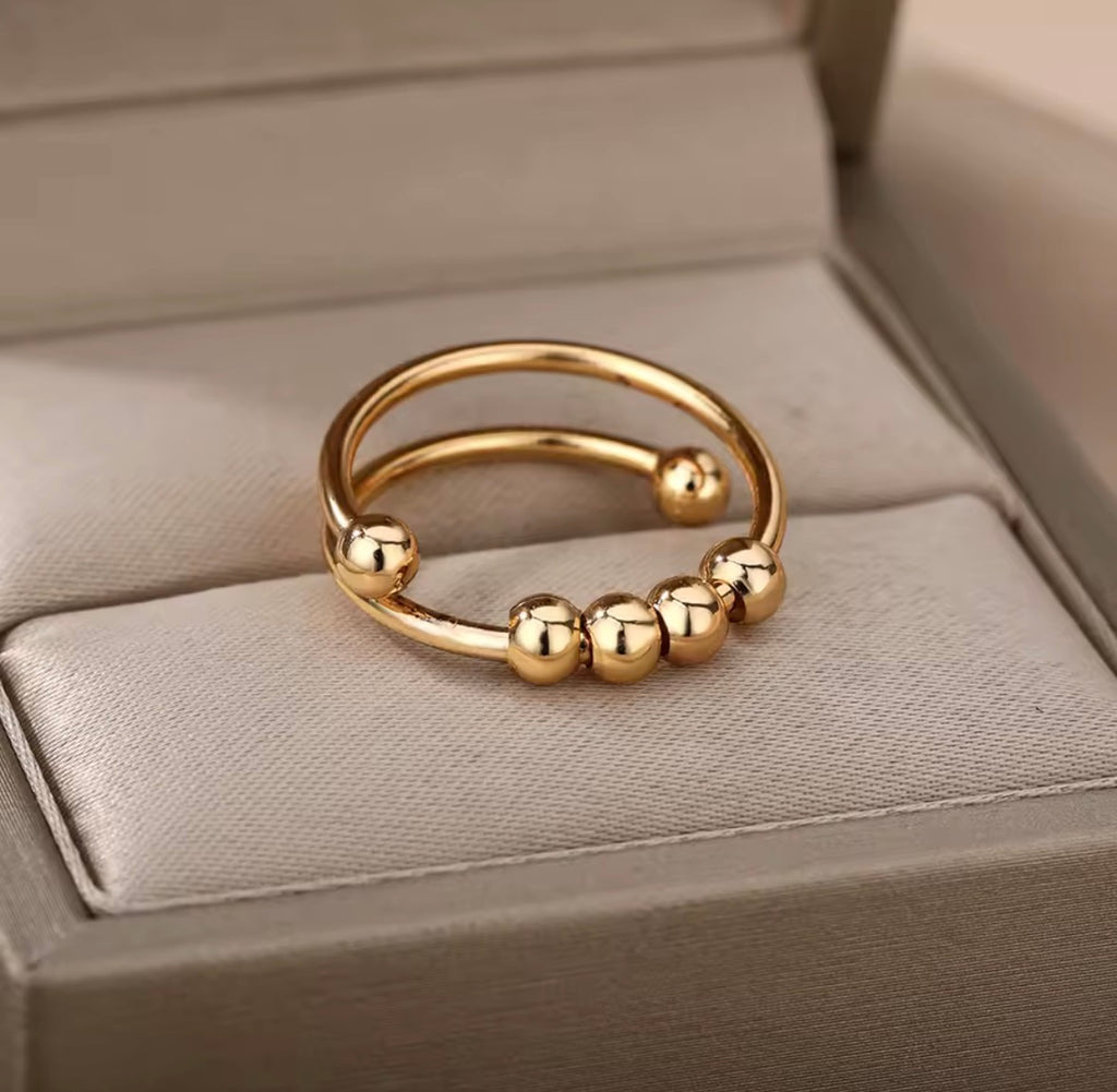 Anti-Anxiety Spinner Ring Gold ring with bead details on a textured surface