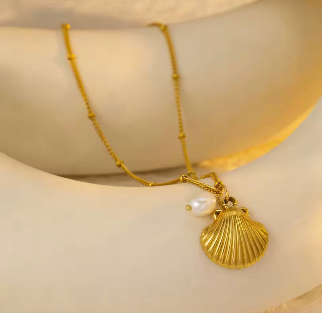 Close-Up of The Marina Shell Pendant with Real Pearl Necklace on beige background