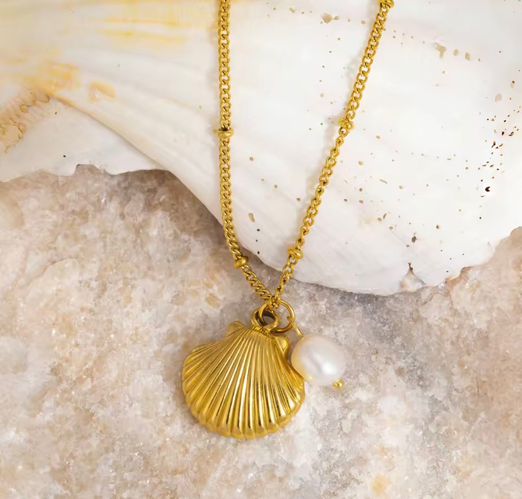 Close-Up of The Marina Shell Pendant with Real Pearl Necklace on shell background