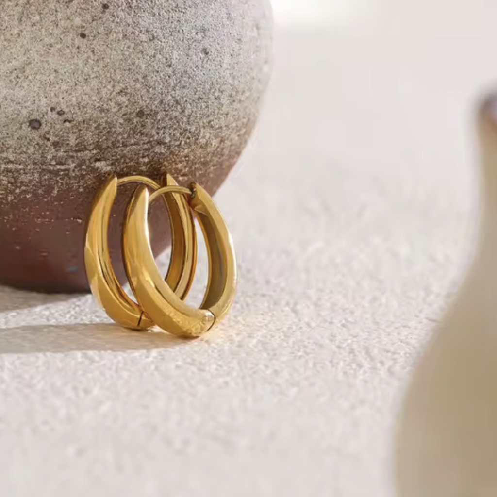 Close-up of Nova Hoops 18K PVD gold U-shape hoop earrings showing polished finish and geometric design.