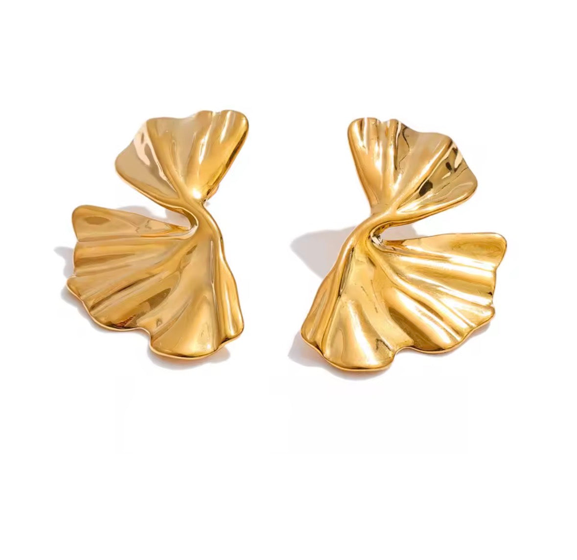 A pair of gold-toned, textured leaf-shaped earrings with a polished, reflective finish, displayed on a clean white background.