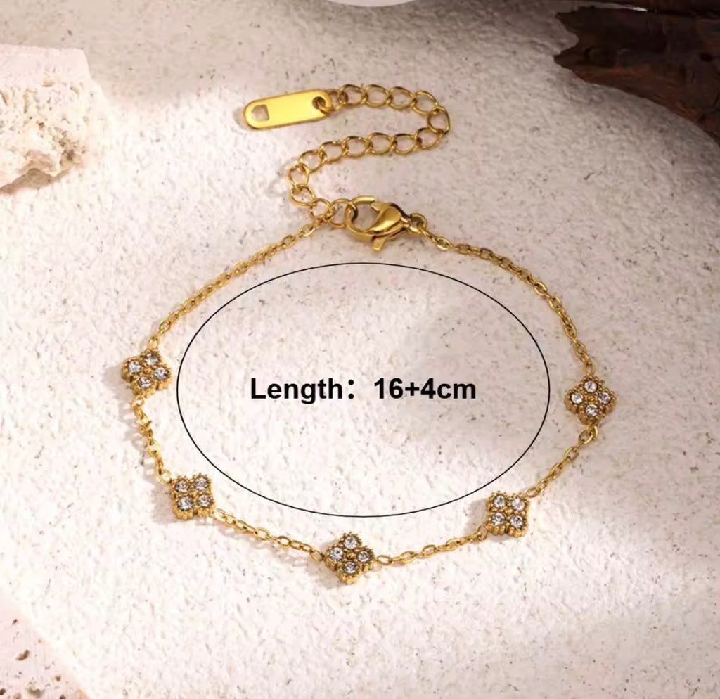 Shop The Florielle Bracelet – a delicate gold-tone stainless steel bracelet with sparkling cubic zirconia flowers. Adjustable, hypoallergenic and perfect for gifting.