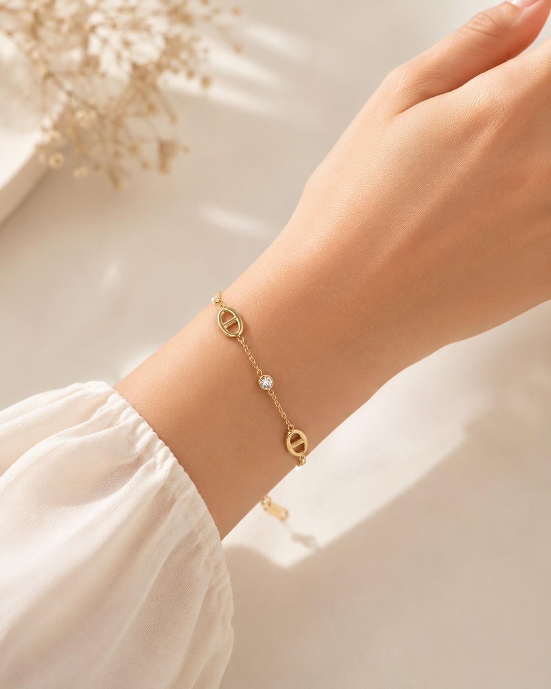 Shop The Celestine Bracelet – an elegant gold-tone stainless steel bracelet with geometric oval motifs and sparkling white zircon accents. Adjustable and hypoallergenic.