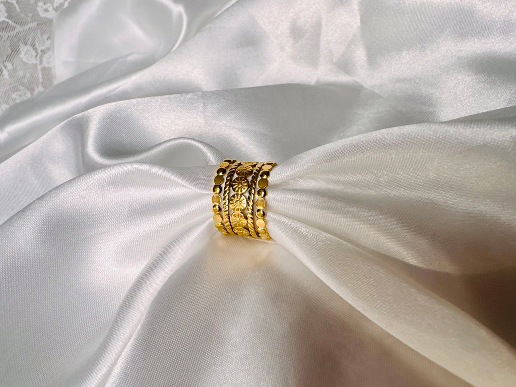 The Alessia Ring Gold ring on a white satin fabric