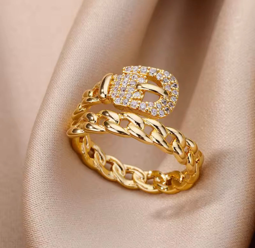 The Cintra Ring with diamond accents on a beige fabric background