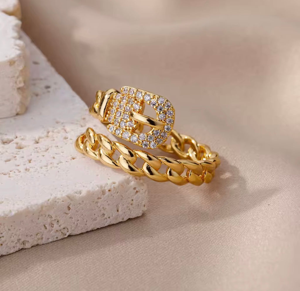 The Cintra Ring  with diamond accents on a textured beige surface