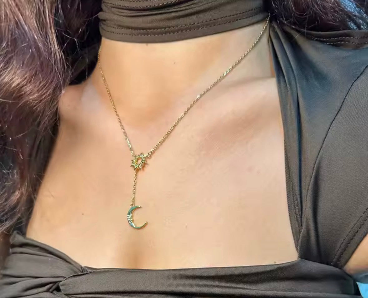 The Eclipse Necklace with a crescent moon pendant worn by a person