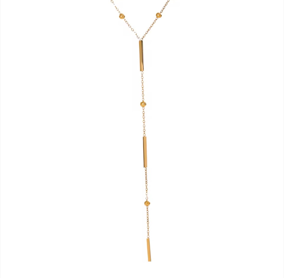 The Elisse Necklace A gold Y-shaped lariat necklace featuring three elongated cylindrical bar charms and three small round bead charms on a delicate chain, displayed against a solid white background.