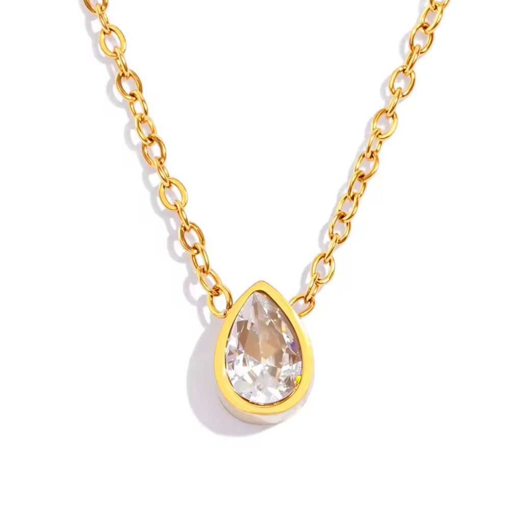 Gold necklace with a teardrop-shaped crystal pendant on a white background