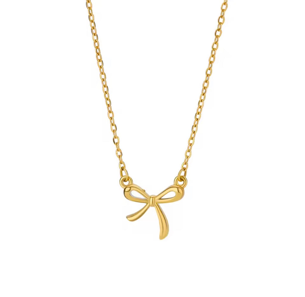 The Eloise Necklace: Gold bow-shaped pendant on a chain against a white background