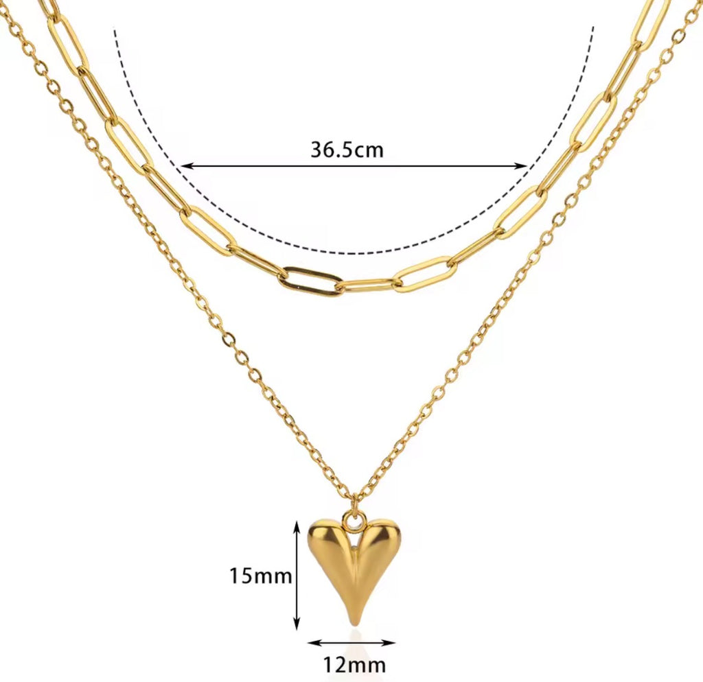 The Fiera Necklace Gold necklace with a heart pendant and measurements on a white background