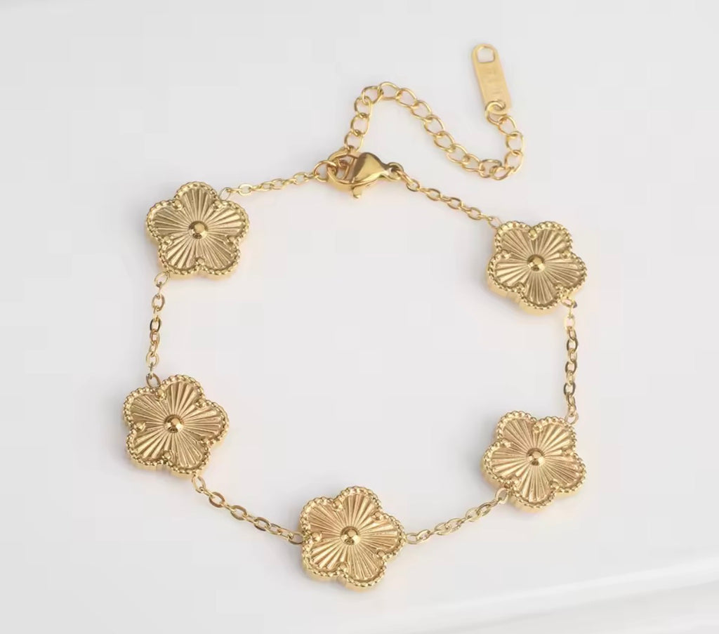 The Fiore Bracelet A gold-tone chain bracelet featuring five textured, flower-shaped links, displayed on a clean white background.