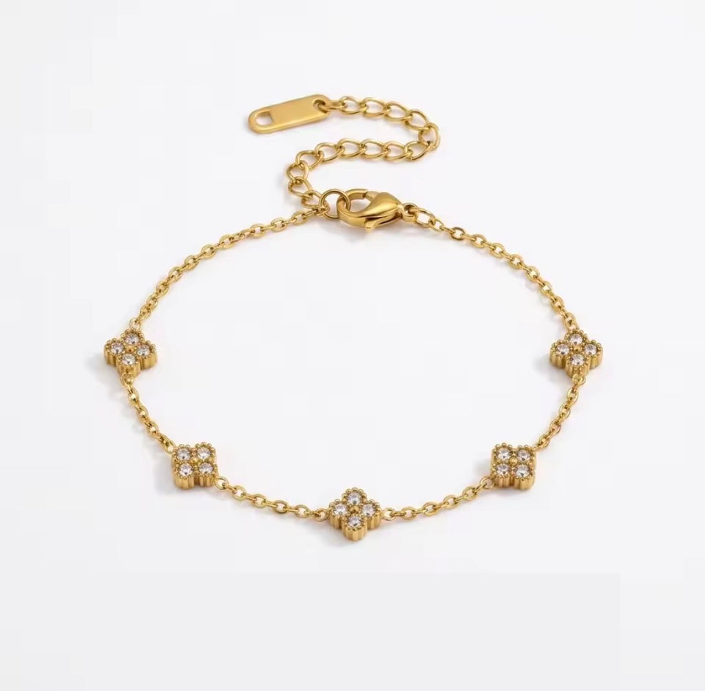Shop The Florielle Bracelet – a delicate gold-tone stainless steel bracelet with sparkling cubic zirconia flowers. Adjustable, hypoallergenic and perfect for gifting.