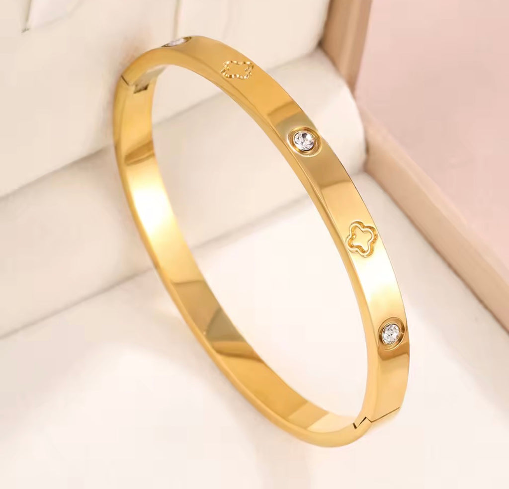 The Fortuna Clover Bangle with diamond accents on a soft background