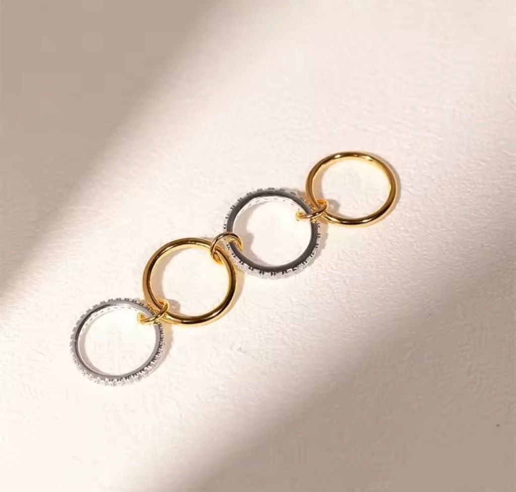 The Harmony Ring Set gold and silver hoop earrings on a light background