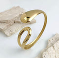The Imperia Bangle Gold bracelet on a light gray background