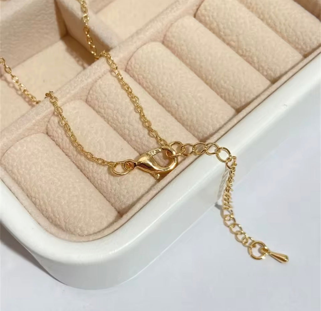 The Lovers Necklace Gold bracelet on a jewelry box with beige interior