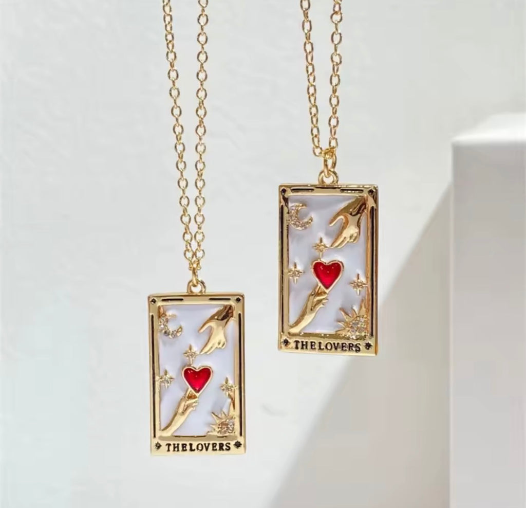 The Lovers Necklace Two gold necklaces with tarot card designs featuring a heart and two cards on a white background.