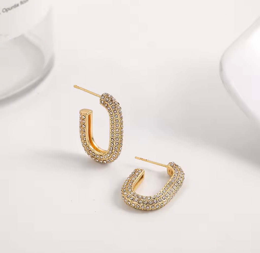 The Lyra Huggies hoop earrings with embedded stones on a white background