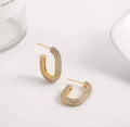 The Lyra Huggies hoop earrings with embedded stones on a white background