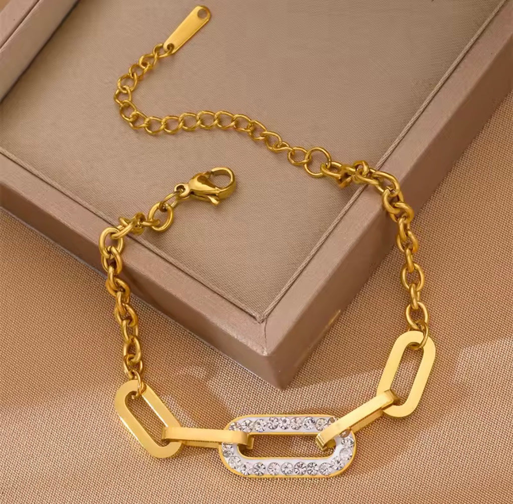 Shop The Maëva Bracelet – a bold 316L stainless steel link bracelet with 18K PVD gold plating and sparkling crystal detail. Waterproof and tarnish-resistant.