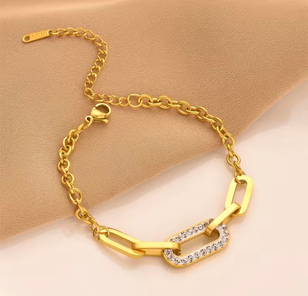 Shop The Maëva Bracelet – a bold 316L stainless steel link bracelet with 18K PVD gold plating and sparkling crystal detail. Waterproof and tarnish-resistant.