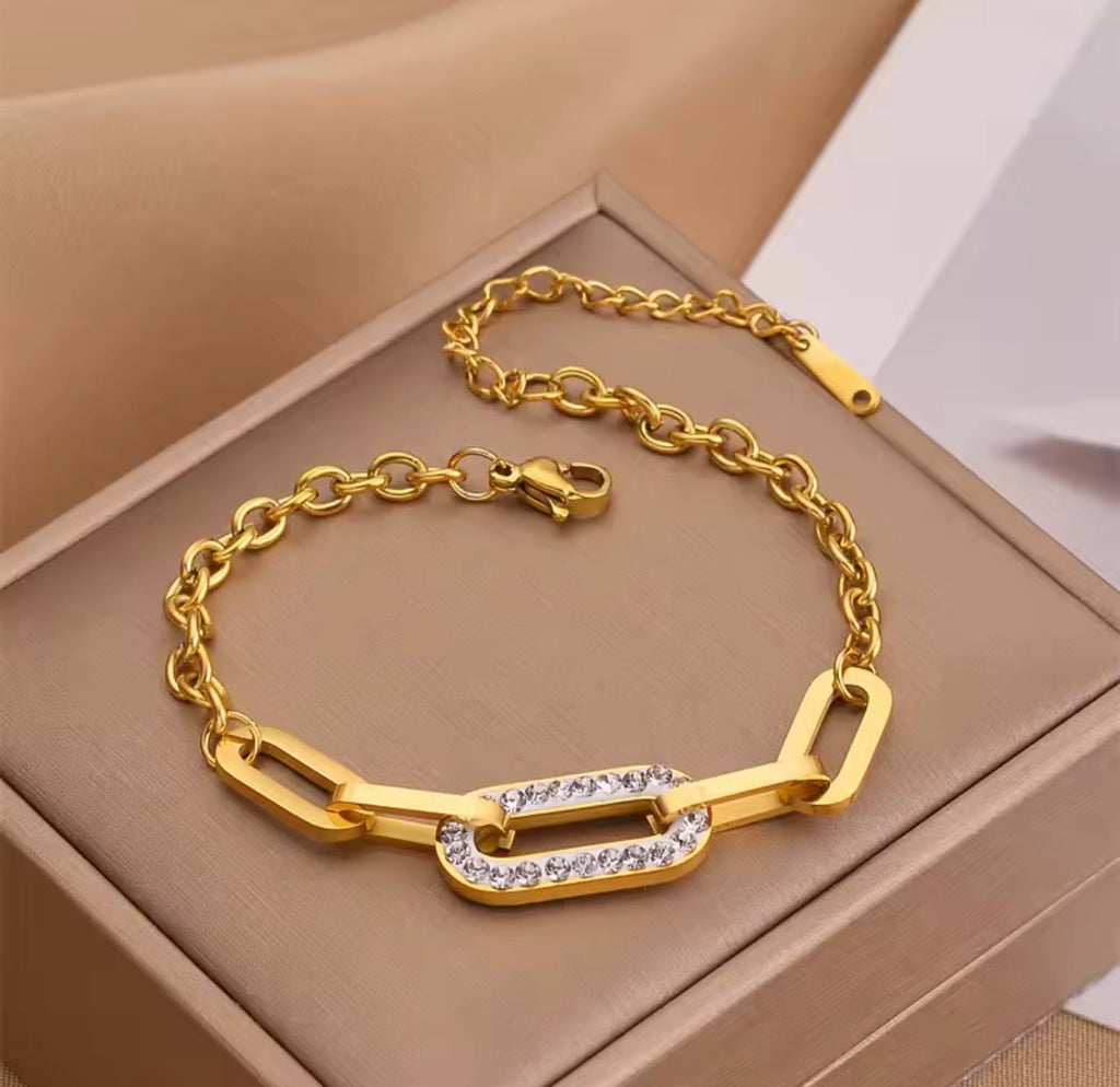 Shop The Maëva Bracelet – a bold 316L stainless steel link bracelet with 18K PVD gold plating and sparkling crystal detail. Waterproof and tarnish-resistant.