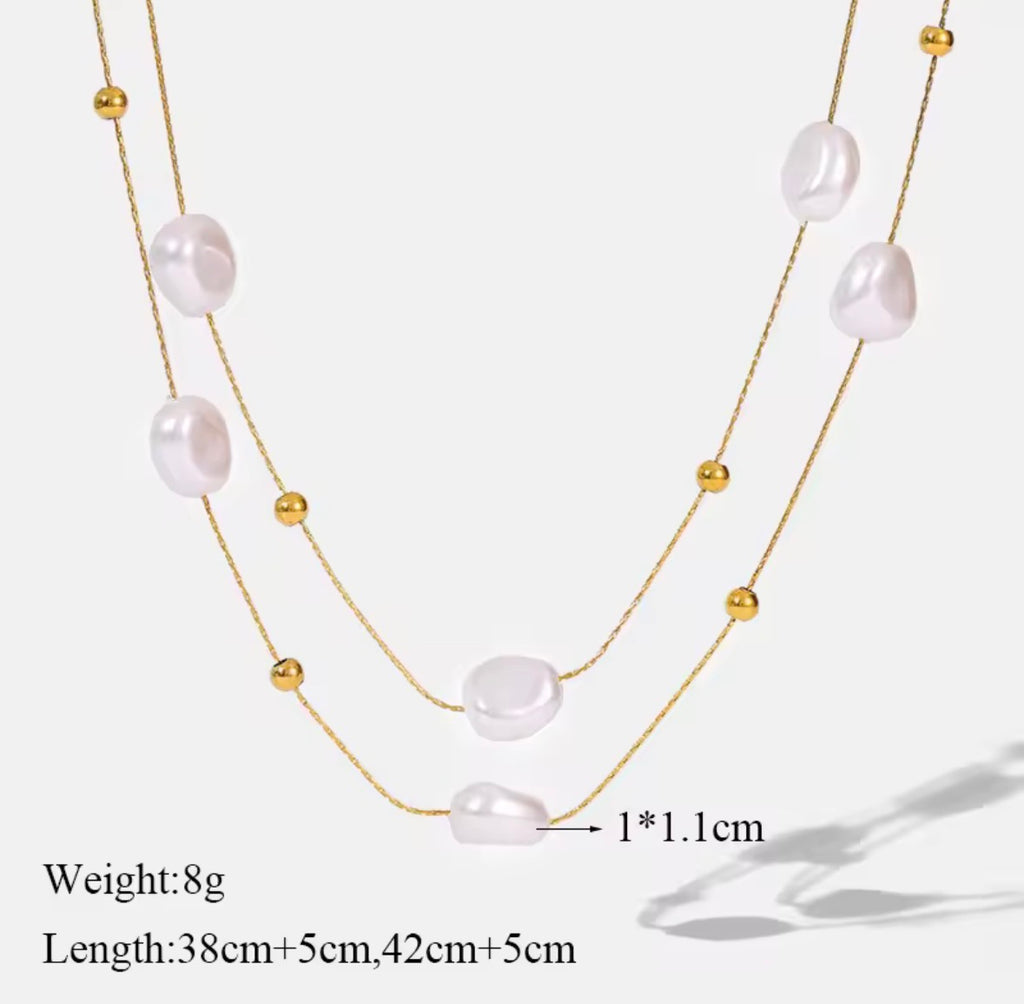 The Mirabelle Necklace  Multi-layered pearl necklace with gold beads on a white background