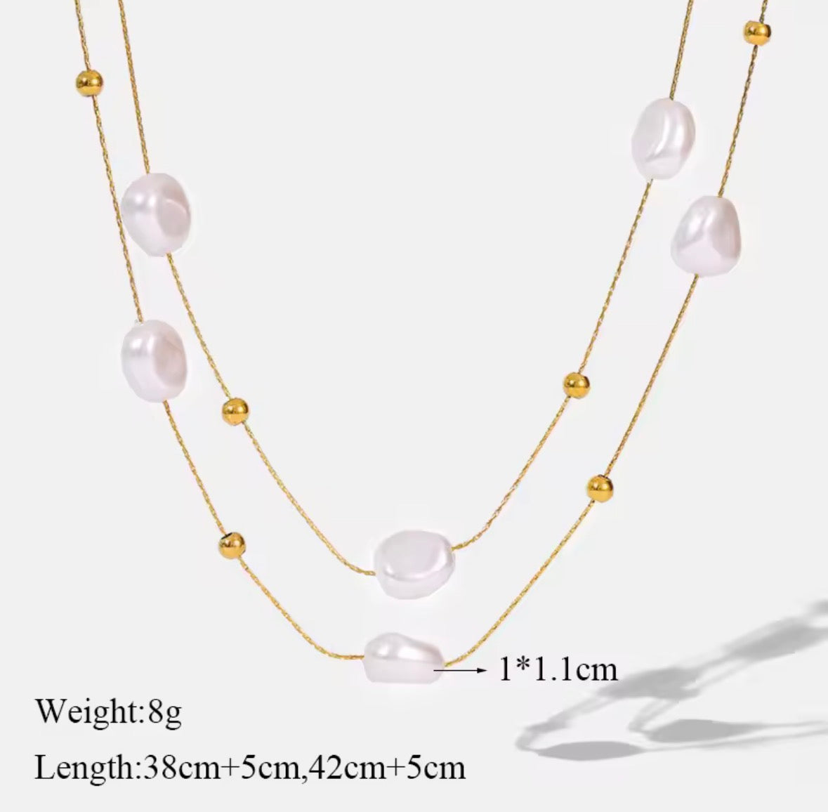 The Mirabelle Necklace  Multi-layered pearl necklace with gold beads on a white background