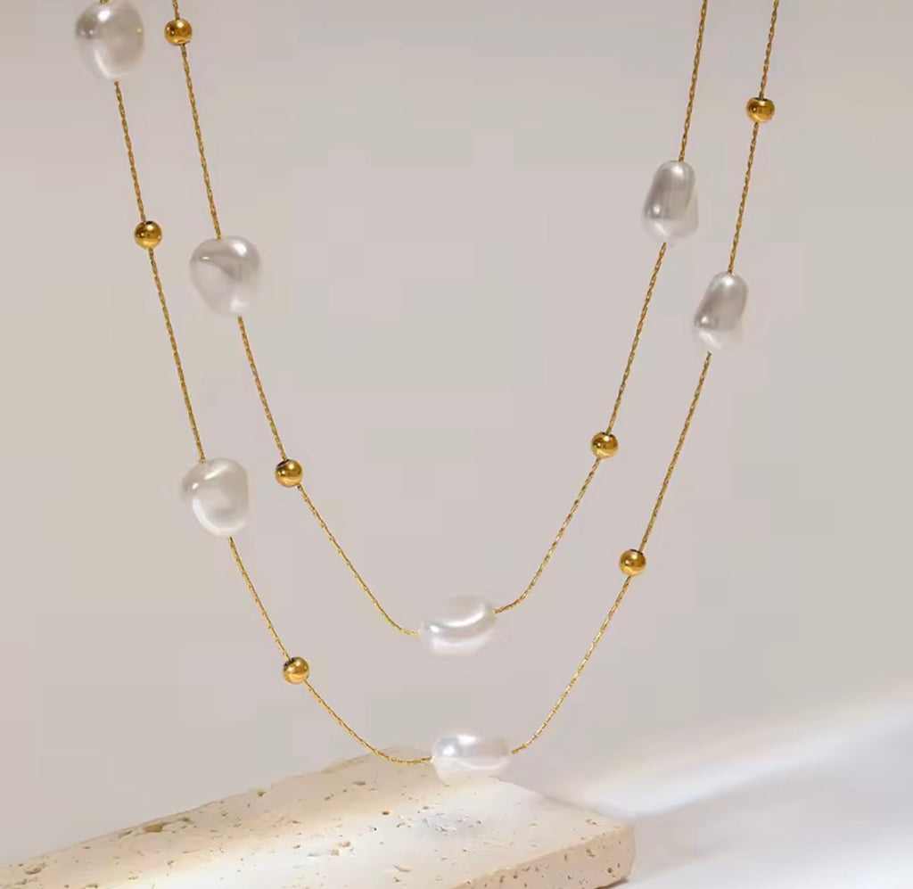The Mirabelle Necklace  Necklace with pearls and gold beads on a light background