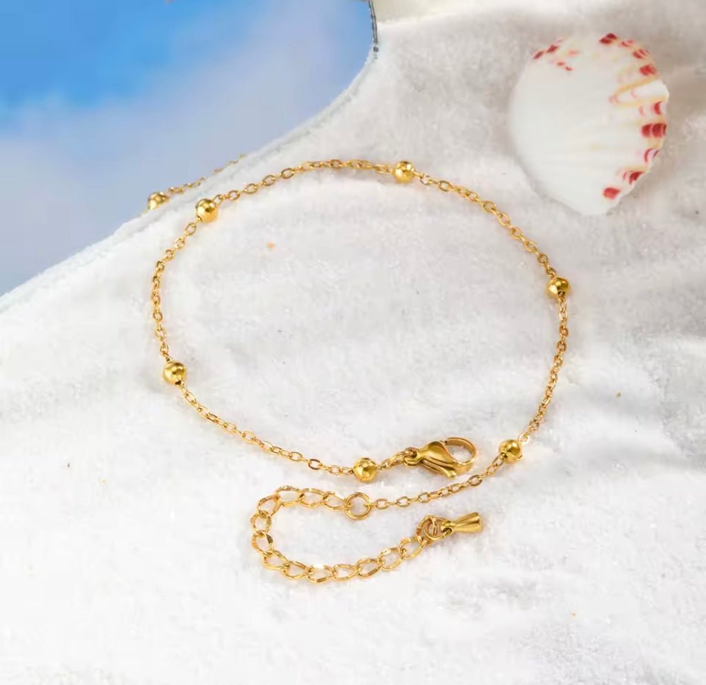 The Oriana Anklet | Waterproof Gold Beaded Chain Anklet for Women  Gold anklet on a white surface with a blue background