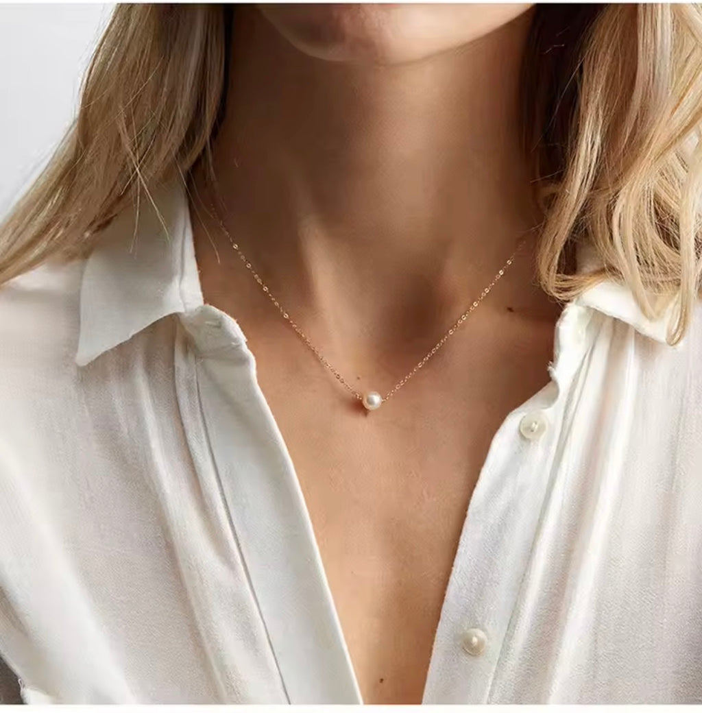 The Perla Necklace  Pearl necklace worn by a person with a white shirt