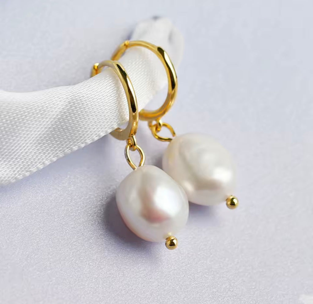 The Perlina Studs  Pearl earrings with gold hooks on a white background