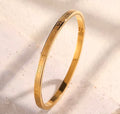  The Romanova Bangle bracelet with an engraved design on a light beige background