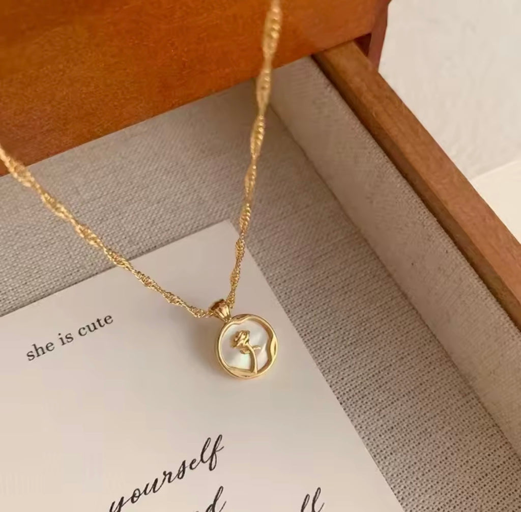 The Rosa del Mar necklace with a pendant on a card with text