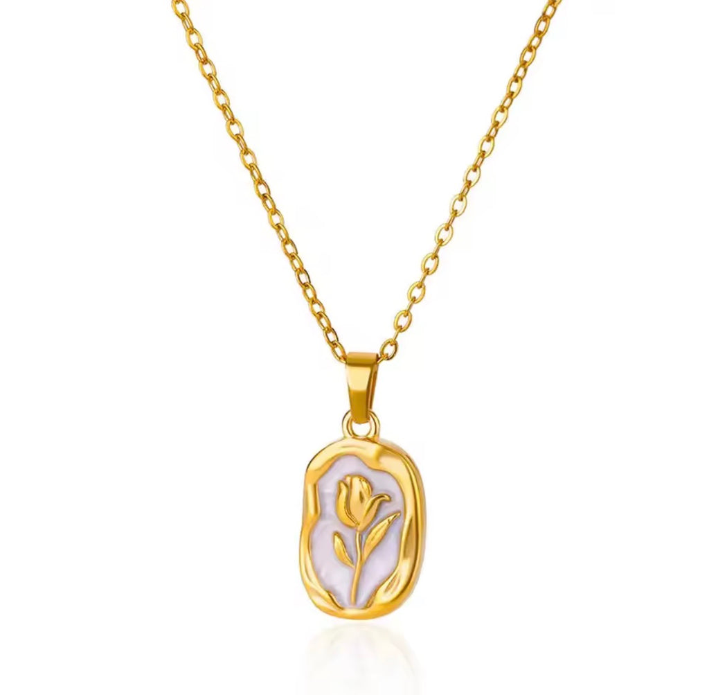 The Rosalie Necklace with a pendant featuring a floral design on a white background