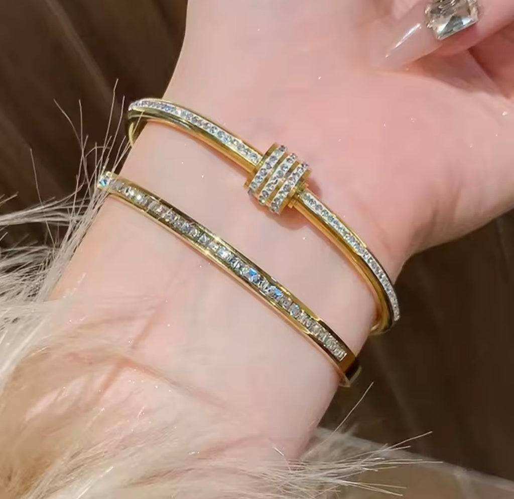  The Selene Bangle  Gold bracelet with gemstones on a wrist against a neutral background