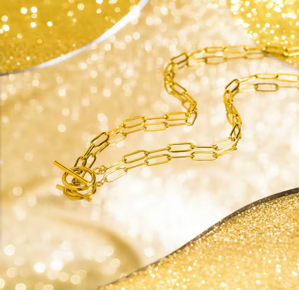 The Valiant chain necklace on a glittery gold background