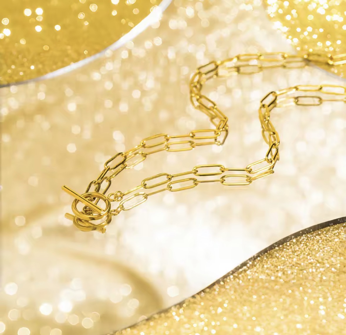 The Valiant chain necklace on a glittery gold background