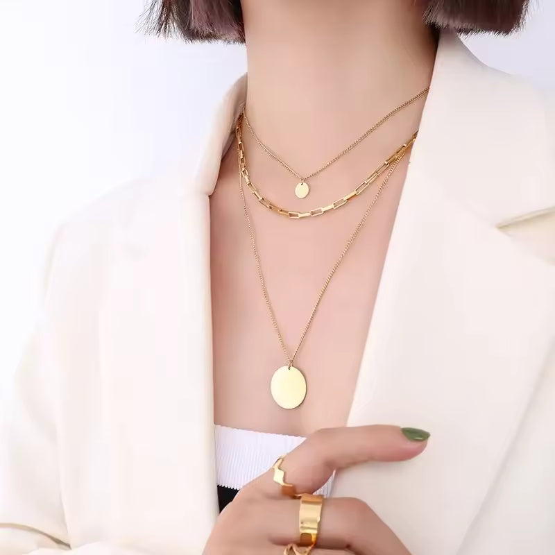 The Valora Necklace   Gold layerd necklaces   on a person wearing a white outfit