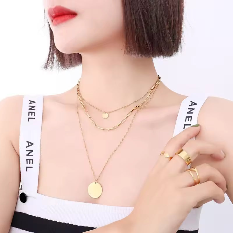 The Valora Necklace: Woman wearing gold layered necklaces  on a white background