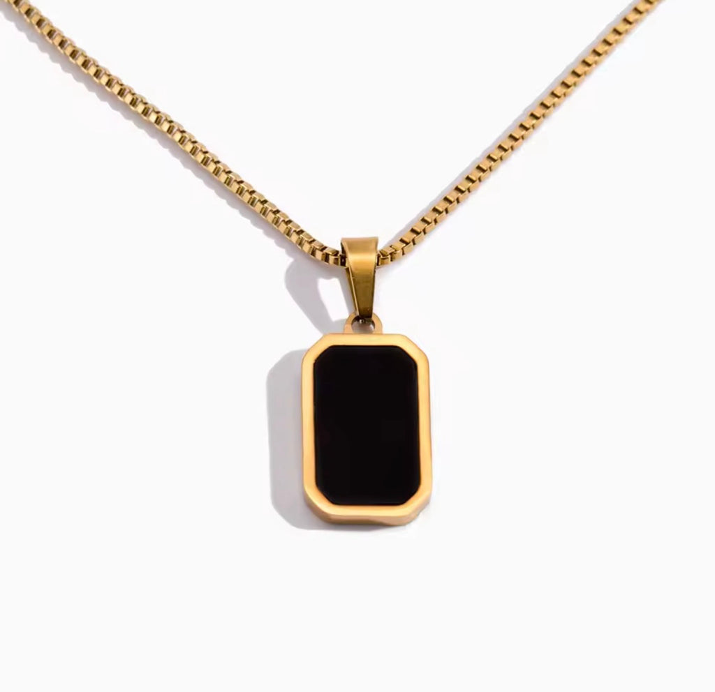 The Vertex Necklace Gold necklace with a black pendant on a white background