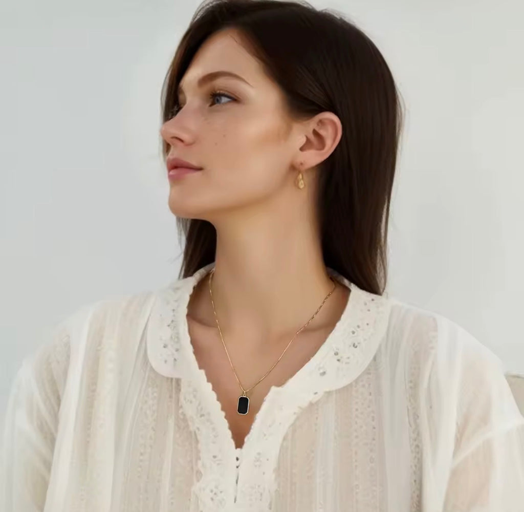 The Vertex Necklace Woman wearing a necklace and earring against a plain background