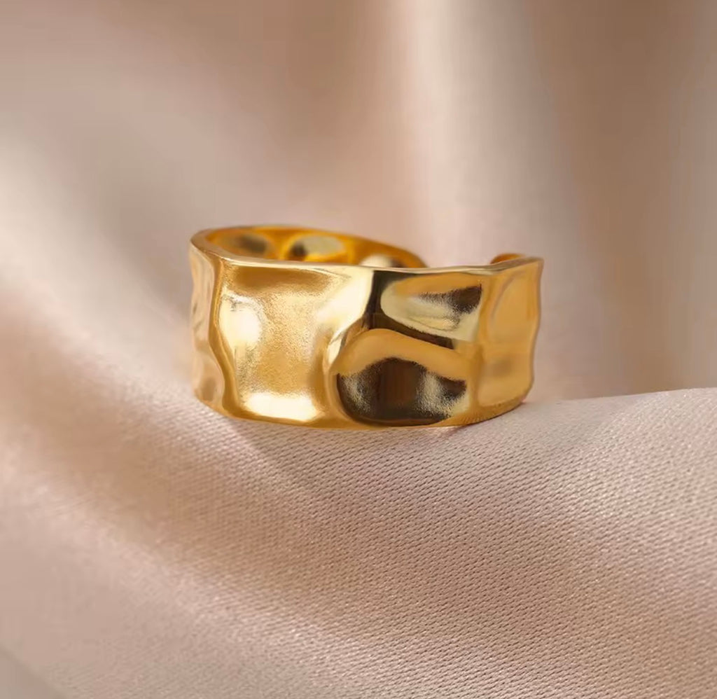 The Vesper Ring Gold ring on a beige fabric background