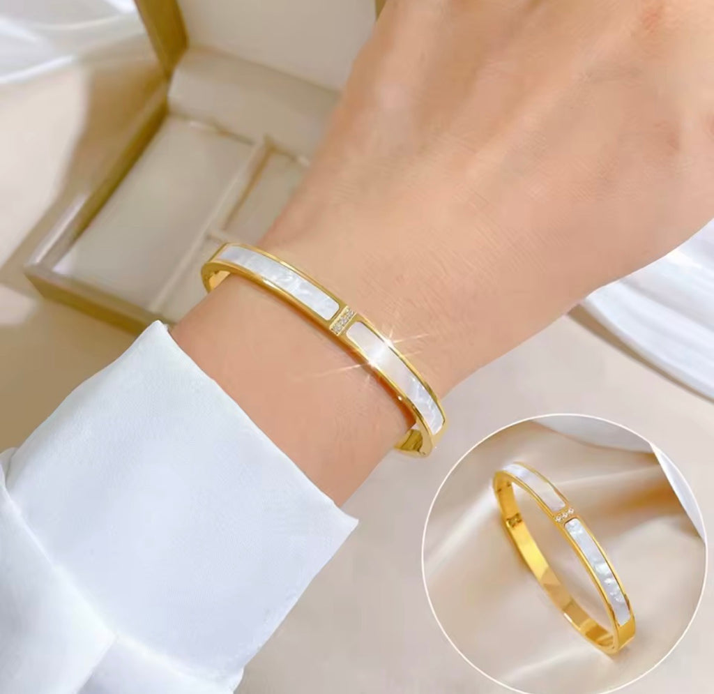 The Vivara Bangle bracelet on a wrist with a close-up inset, set against a neutral background