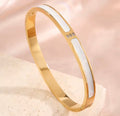 The Vivara Bangle bracelet with a white central section on a beige background