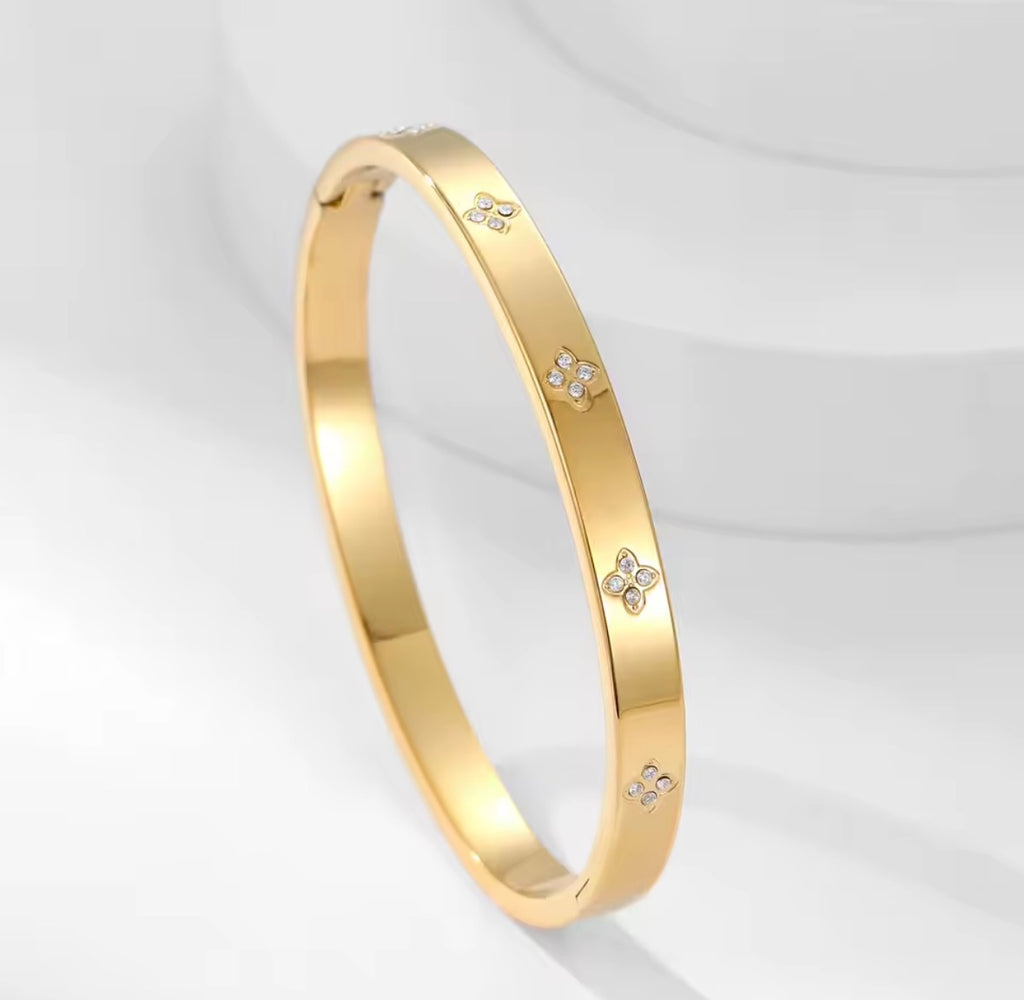 The Zaria Cuff bracelet with floral designs on a light gray background