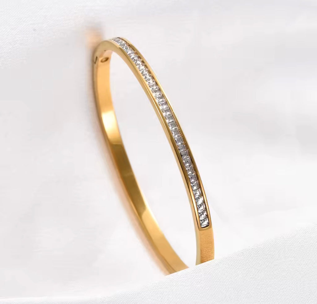 The Éclat Cuff bracelet with embedded diamonds on a light gray background