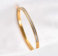 The Éclat Cuff bracelet with embedded diamonds on a light gray background